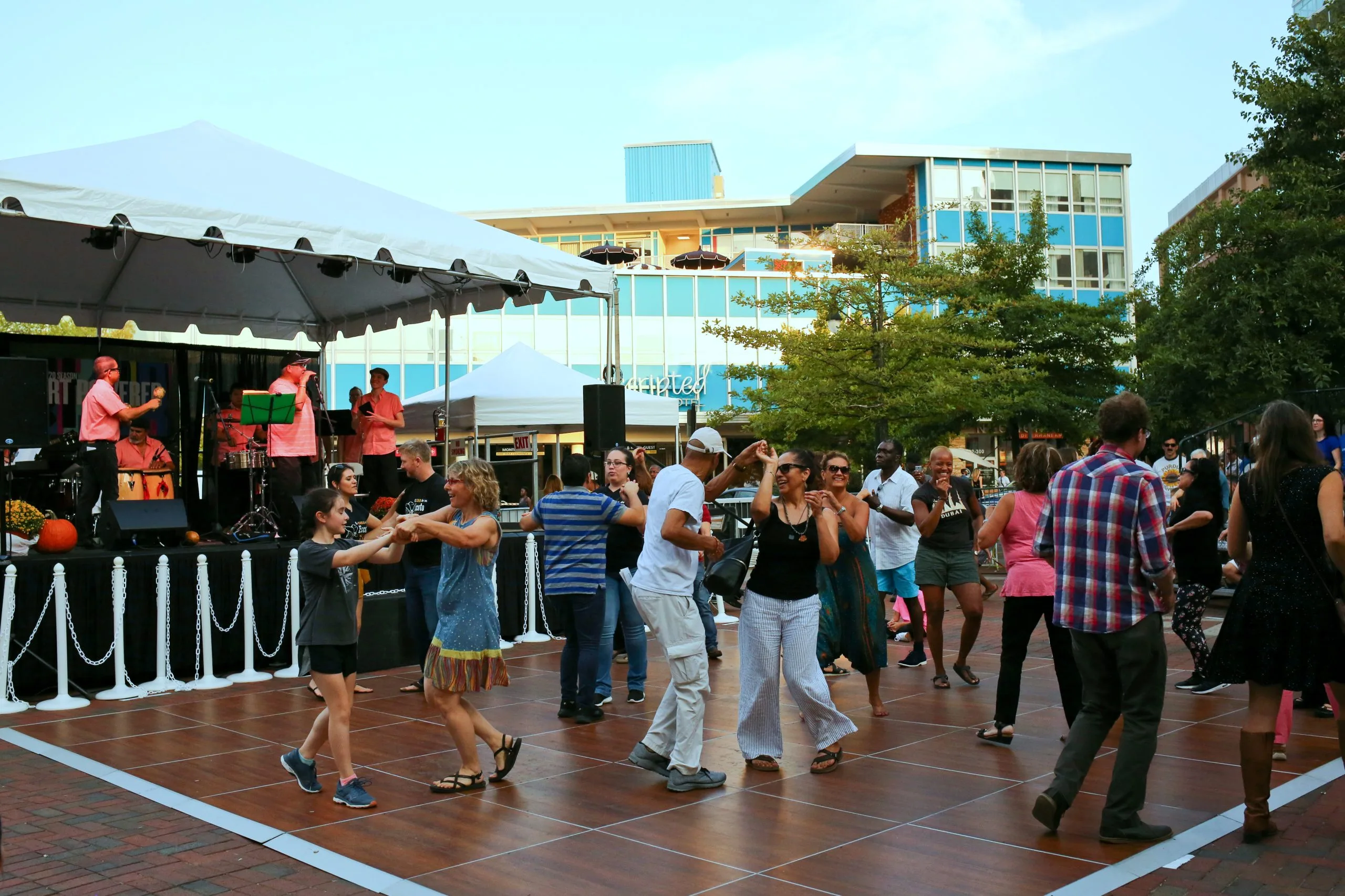 Groups of couples dancing on a temporary dance floor in CCB plaza at dusk